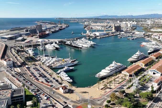 Puerto de recreo con yates de lujo y zona urbana cercana
