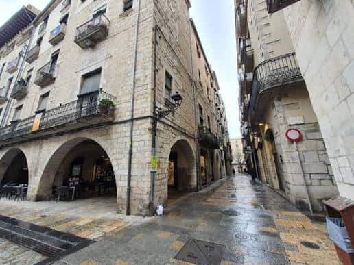 Vista de la calle Carrer dels Abeuradors con arcos de piedra y edificios históricos