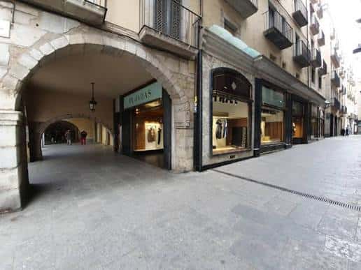 Pasaje cubierto con arcos y tiendas en el Carrer dels Abeuradors