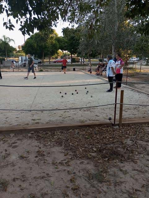 Jugadores de petanca en acción durante un partido en las pistas del club