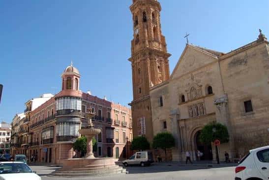 Plaza de San Sebastián con la torre de la iglesia y edificios históricos al atardecer