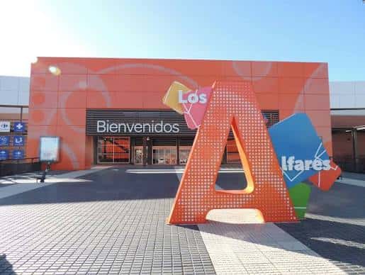 Entrada del centro comercial con escultura de la letra A y letrero Los Alfares