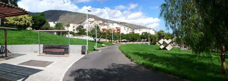 Vista panorámica del parque con senderos, zonas verdes y esculturas modernas