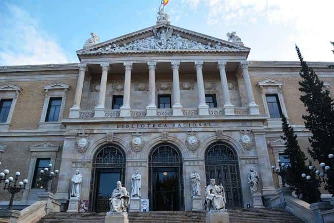Fachada frontal de la Biblioteca Nacional con estatuas y escalinata bajo cielo despejado