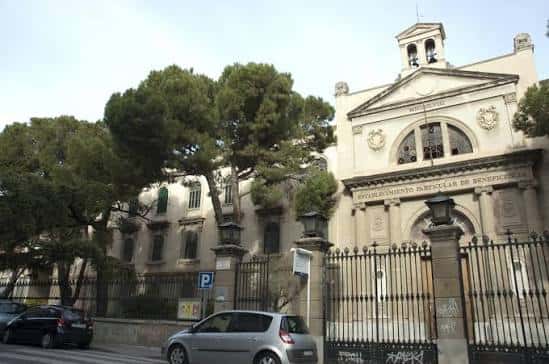 Vista exterior de la fachada principal de Casa Caritat con el letrero 'Establecimiento Particular de Beneficencia'