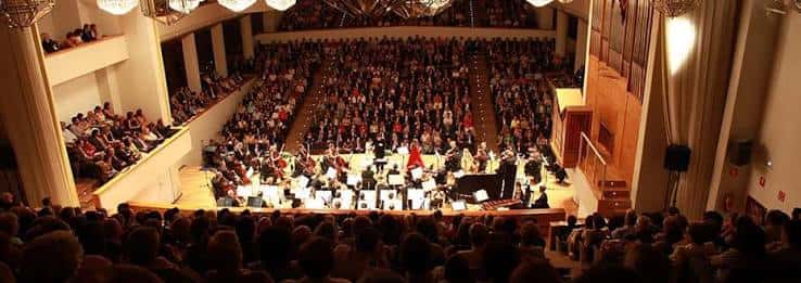 Concierto sinfónico con orquesta completa y audiencia abarrotada