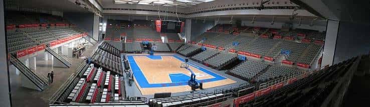Vista panorámica del interior del pabellón con gradas vacías y pista de baloncesto