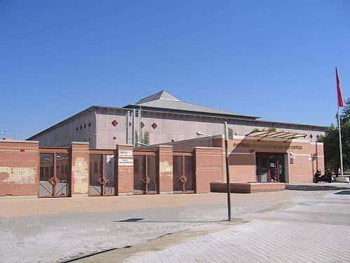 Vista exterior del Palacio Municipal de Deportes de Granada bajo un cielo despejado