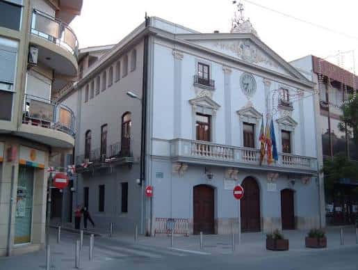 Vista exterior de la Casa de la Cultura en Torrent con fachada clásica y banderas