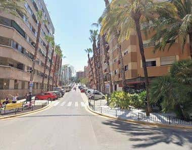 Calle principal de la Avenida al Vedat con coches aparcados y palmeras
