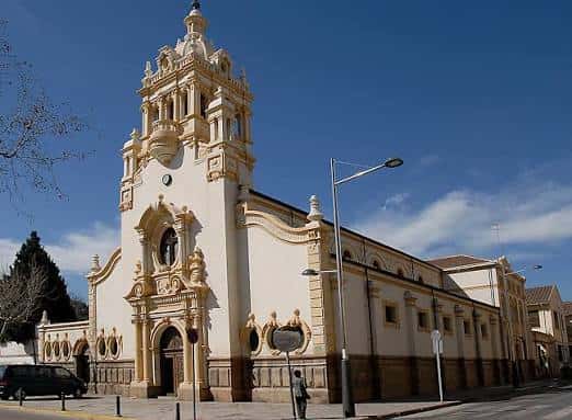 Fachada principal de la Iglesia de Nuestra Señora de Begoña con torre ornamental y cielo despejado