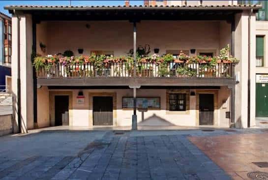 Vista frontal de la Casa del Chino con su balcón adornado de flores