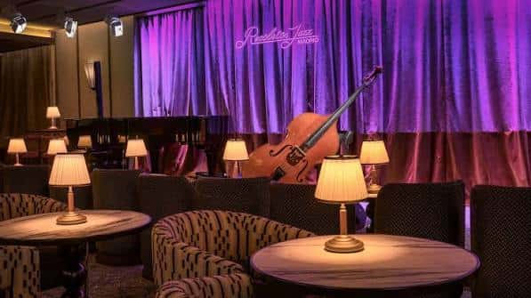 Interior elegante del club con mesas y cortinas púrpuras