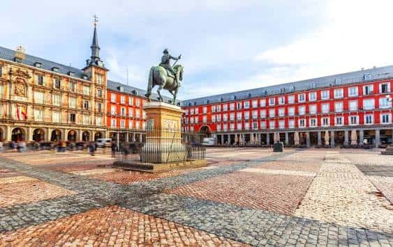Plaza Mayor desde ángulo bajo, destacando la estatua de Felipe III y los arcos de las edificaciones circundantes