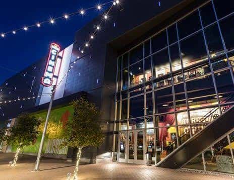 Fachada exterior del Alamo Drafthouse Mueller de noche con iluminación y letrero