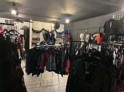 Interior de la boutique con percheros y ropa de estilo gótico