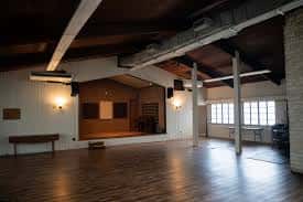 Salón principal con piso de madera y escenario al fondo