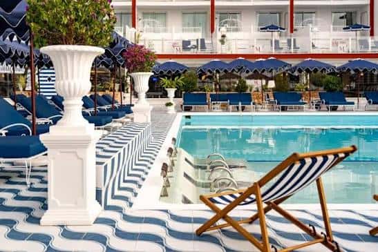 Piscina del hotel rodeada de tumbonas y sombrillas con decoración clásica