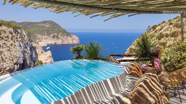 Zona de descanso junto a la piscina con vistas al acantilado y el mar