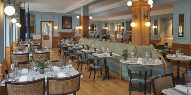 Sala de restaurante del hotel con mesas dispuestas para cena y decoración elegante