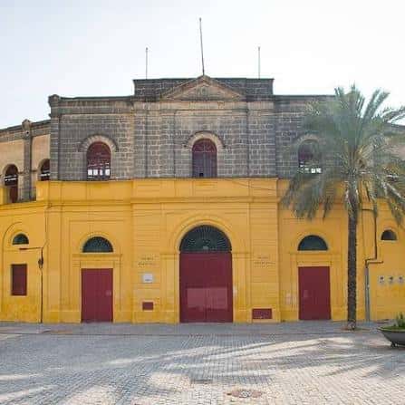 Fachada principal de la Plaza de Toros de Jerez con palmeras y cielo despejado
