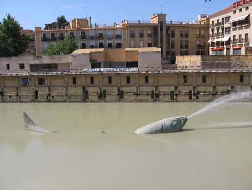 Vista exterior del Museo Hidráulico con esculturas de peces en el río