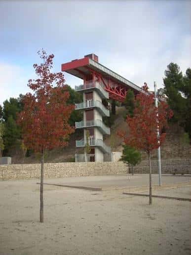 Edificio moderno con estructura roja y balcones en el interior del Parc de Valldaura