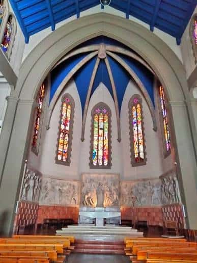 Interior del altar principal con vitrales coloridos y bóveda azul