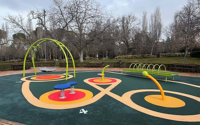 Equipamiento de juegos infantiles en el Parque de Adoratrices con árboles de fondo