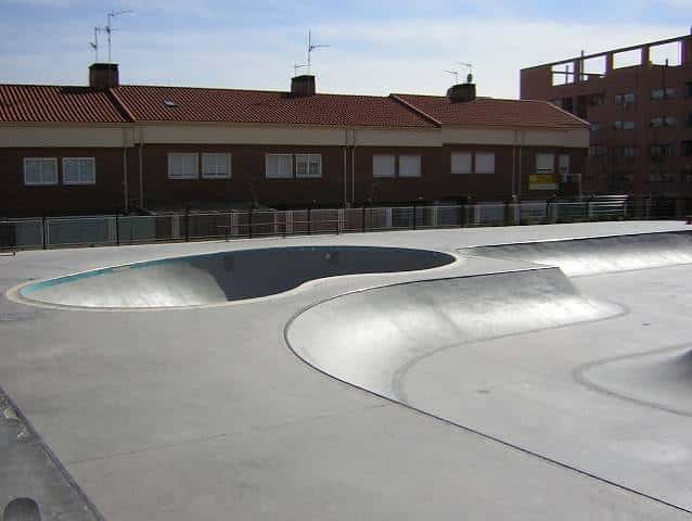 Vista del skatepark en el Parque Los Rosales con rampas de concreto y edificios residenciales al fondo