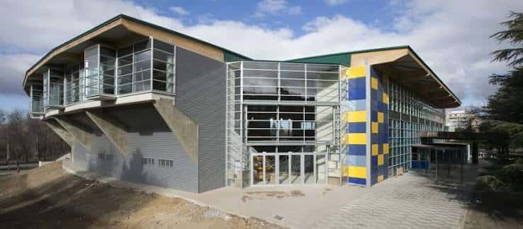 Vista exterior del Pabellón Municipal de Deportes con fachada moderna y detalles en azul y amarillo