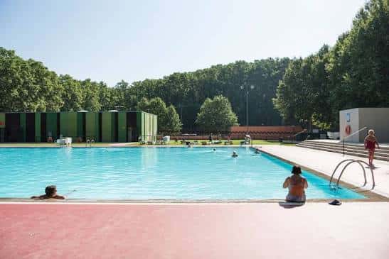 Piscina municipal de la Devesa con personas nadando y descansando en la orilla
