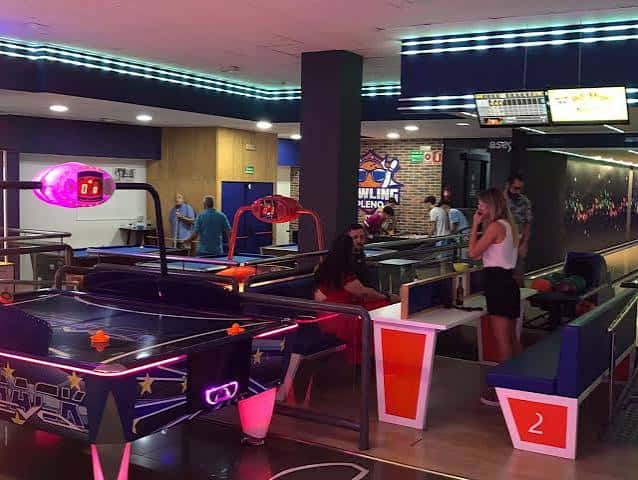 Área de entretenimiento con máquinas de aire y pistas de bolos