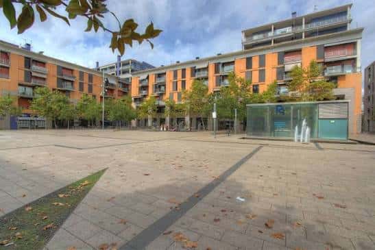 Vista general de la Plaça de la Mediterrània con edificios residenciales y zona ajardinada