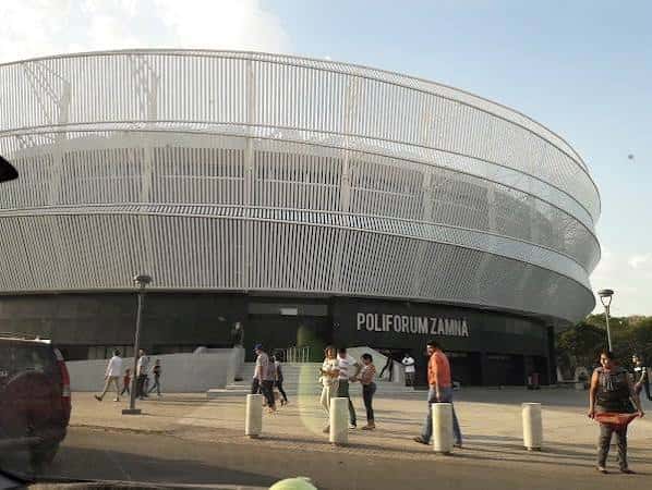 Entrada principal del Polifórum Zamná con su distintiva fachada de malla metálica y personas transitando
