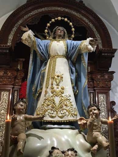 Estatua de la Virgen de la Asunción en su nicho con detalles ornamentales y ángeles