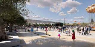 Espacio público exterior del recinto con personas disfrutando de actividades al aire libre y zona de juegos