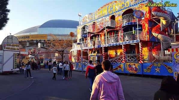 Vista general de la feria en el Recinto Ferial de Leganés con atracciones y público
