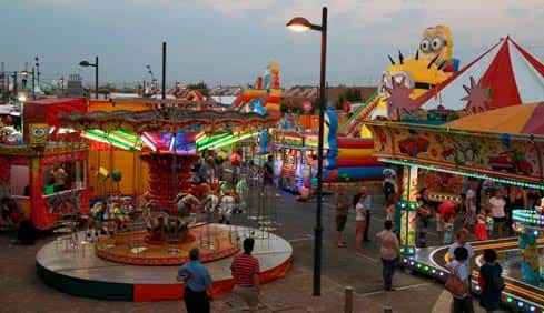 Atracciones y puestos de la feria nocturna en el recinto ferial