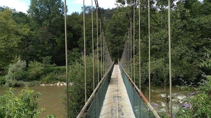 Puente colgante sobre el río en el Parque de la Viesca