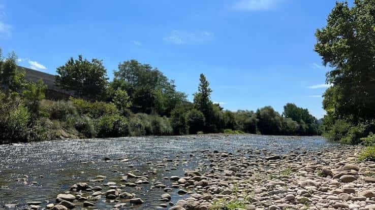 Río Saja con orilla rocosa y vegetación en el Parque de la Viesca