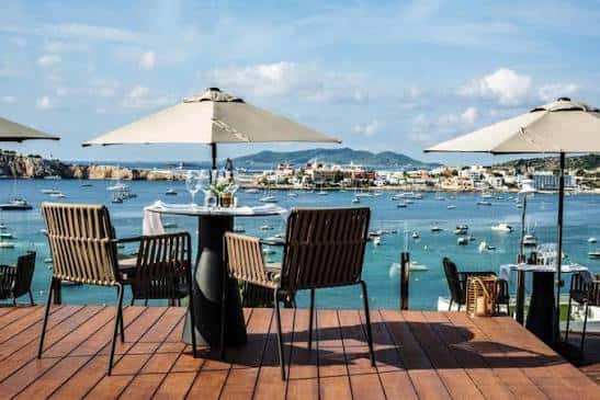 Terraza con mesas y sombrillas con vista al puerto de Talamanca