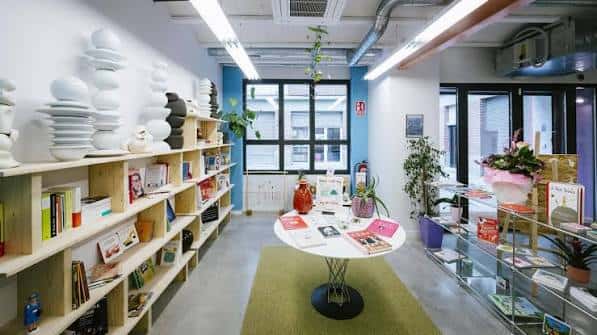 Interior del espacio cultural con estanterías de madera, libros y decoración moderna