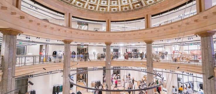 Interior del centro comercial con cúpula decorada y múltiples niveles de tiendas