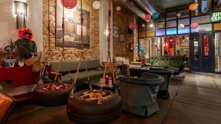 Área de descanso con sillas colgantes de neumáticos y decoración artística