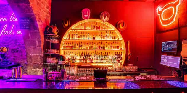 Vista del mostrador del bar con decoración temática y luces rojas