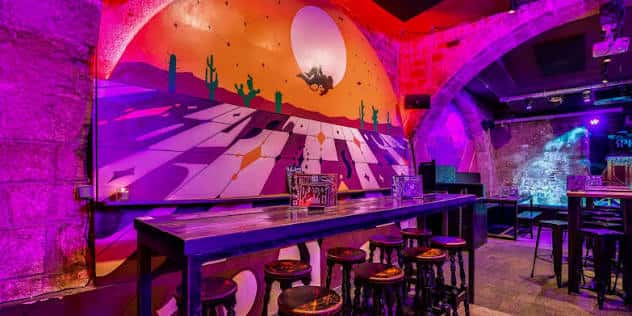 Pared con mural de desierto y luna en el interior del Space Cowboy