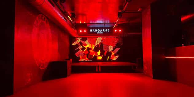 Escenario principal con pantalla LED y luces rojas