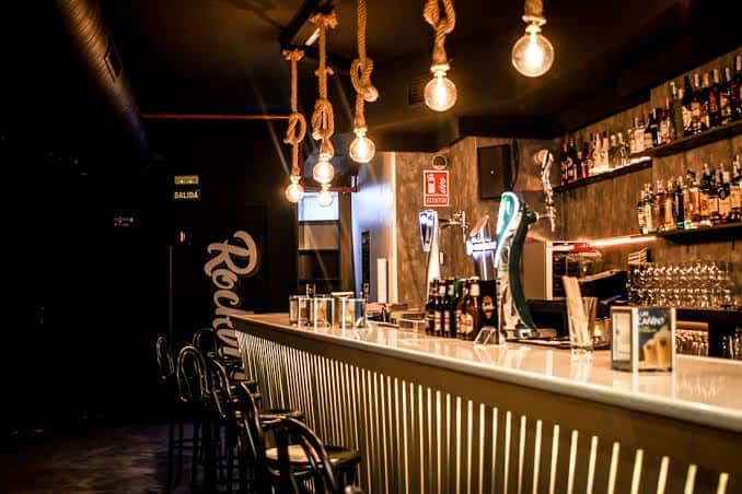 Barra de la sala Rockville con iluminación cálida y decoración industrial