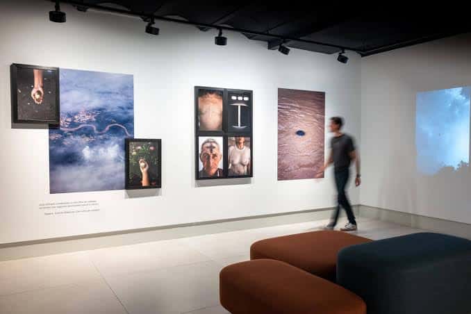 Interior de la galería con exposiciones fotográficas enmarcadas y mobiliario moderno